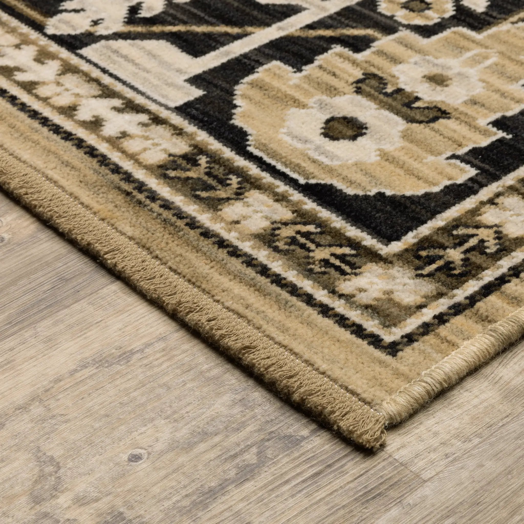 Acacia ACA12 Tan/Charcoal area rug with warm tan ground, charcoal contrast, traditional pattern detail, earthy accents, and cotton fringe.
