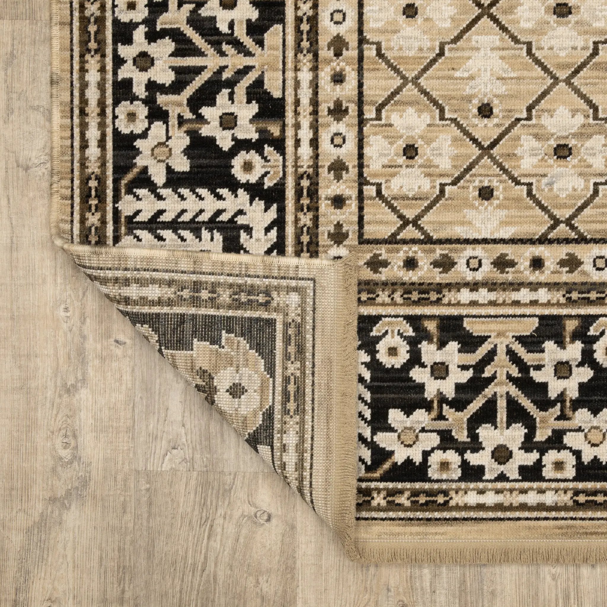 Acacia ACA12 Tan/Charcoal area rug with warm tan ground, charcoal contrast, traditional pattern detail, earthy accents, and cotton fringe.