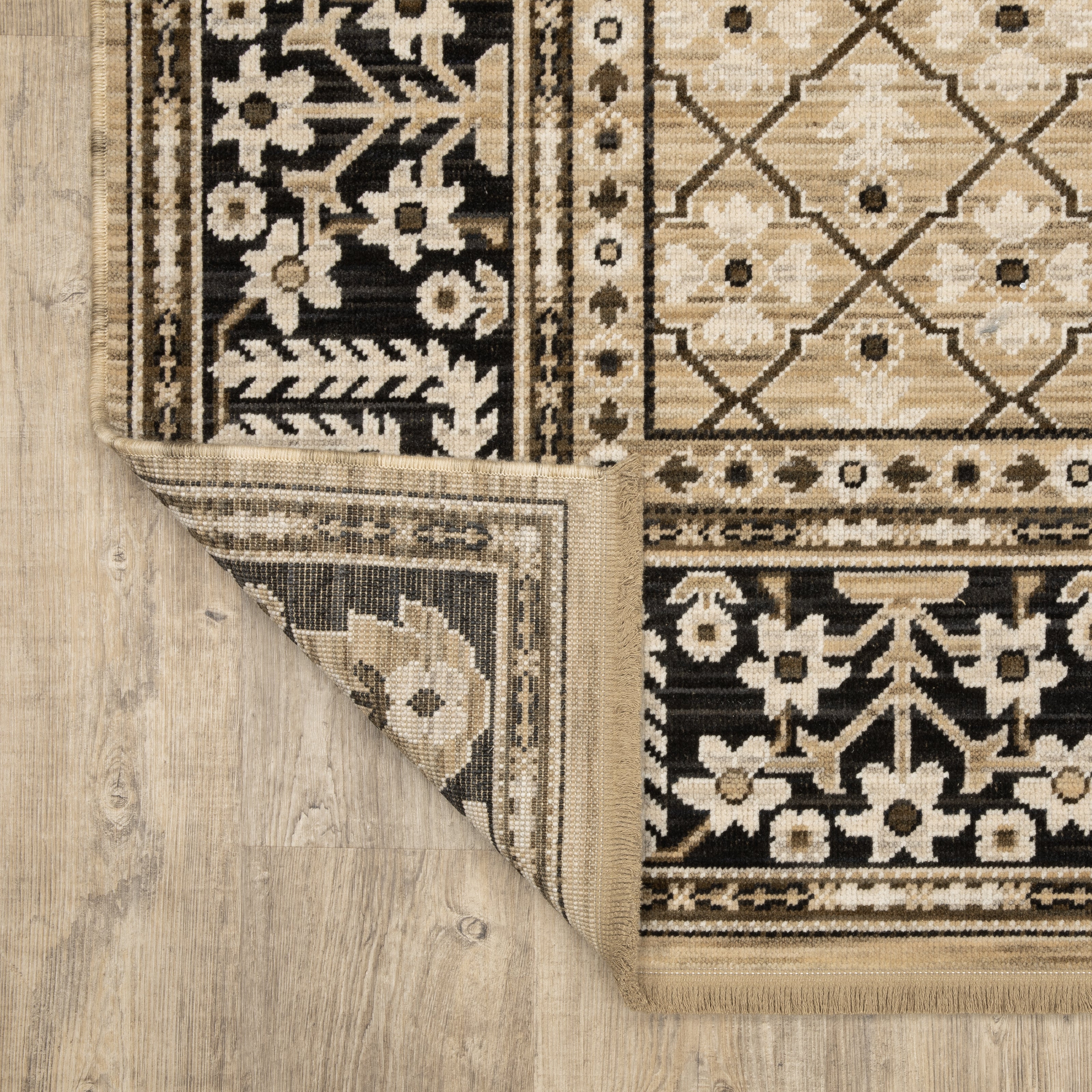 Acacia ACA12 Tan/Charcoal area rug with warm tan ground, charcoal contrast, traditional pattern detail, earthy accents, and cotton fringe.