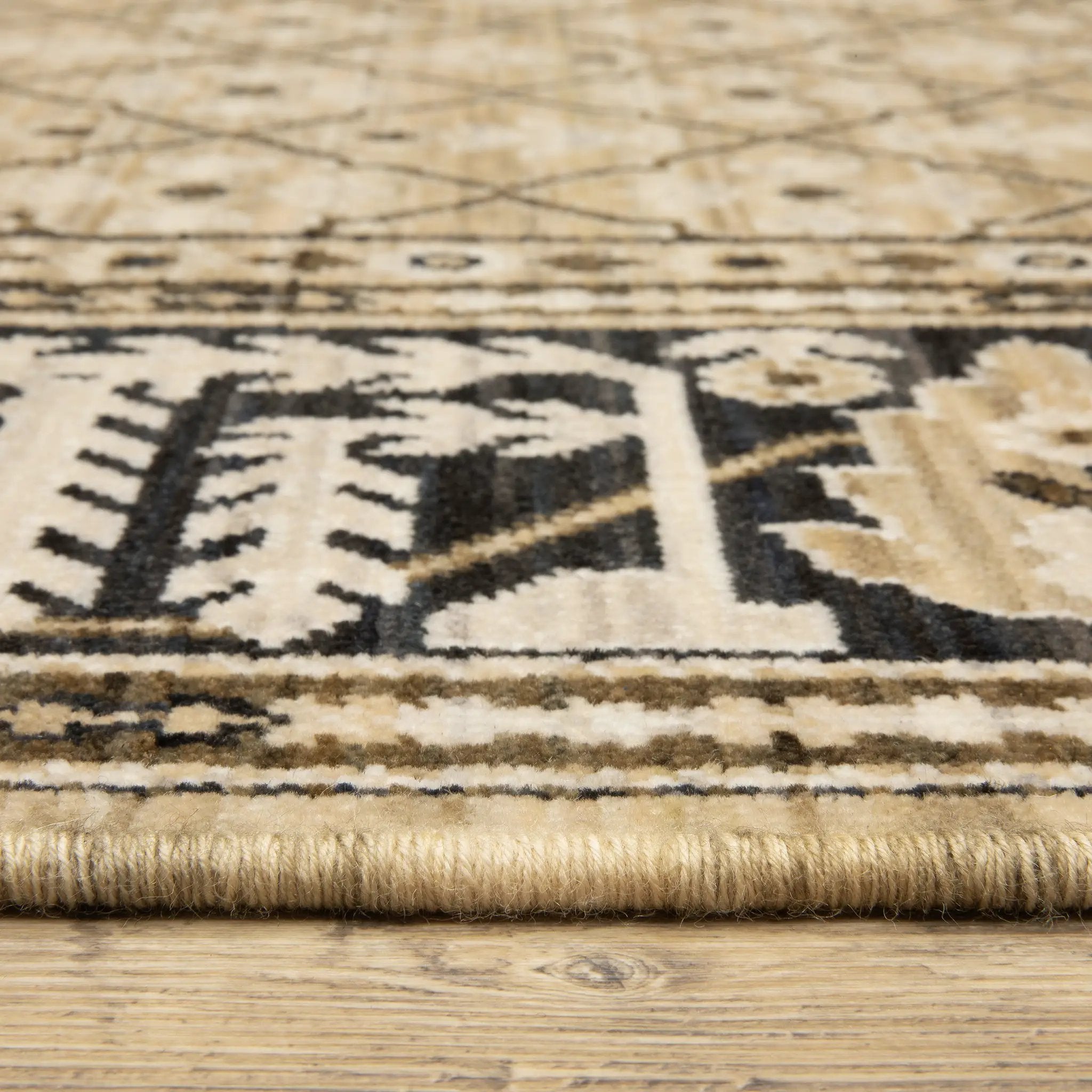 Acacia ACA12 Tan/Charcoal area rug with warm tan ground, charcoal contrast, traditional pattern detail, earthy accents, and cotton fringe.