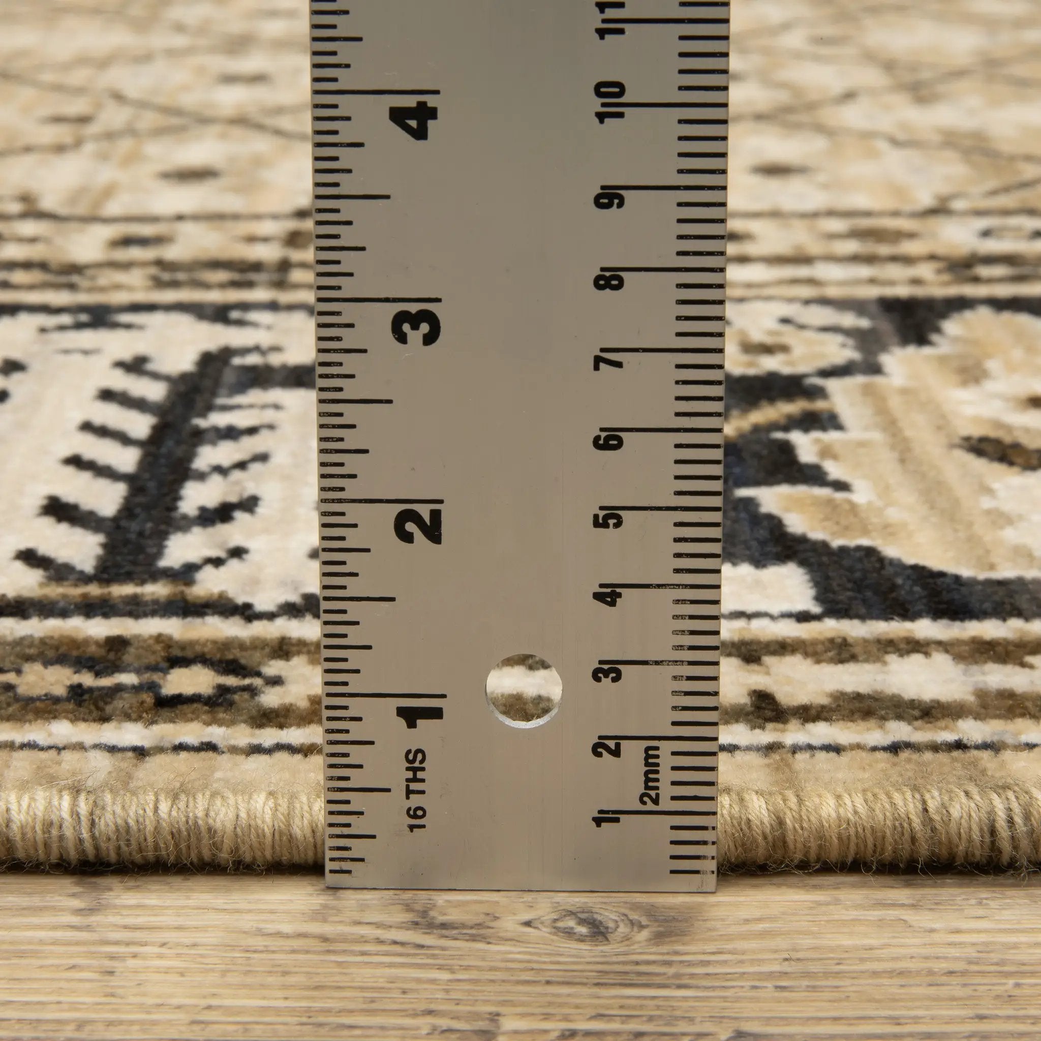 Acacia ACA12 Tan/Charcoal area rug with warm tan ground, charcoal contrast, traditional pattern detail, earthy accents, and cotton fringe.