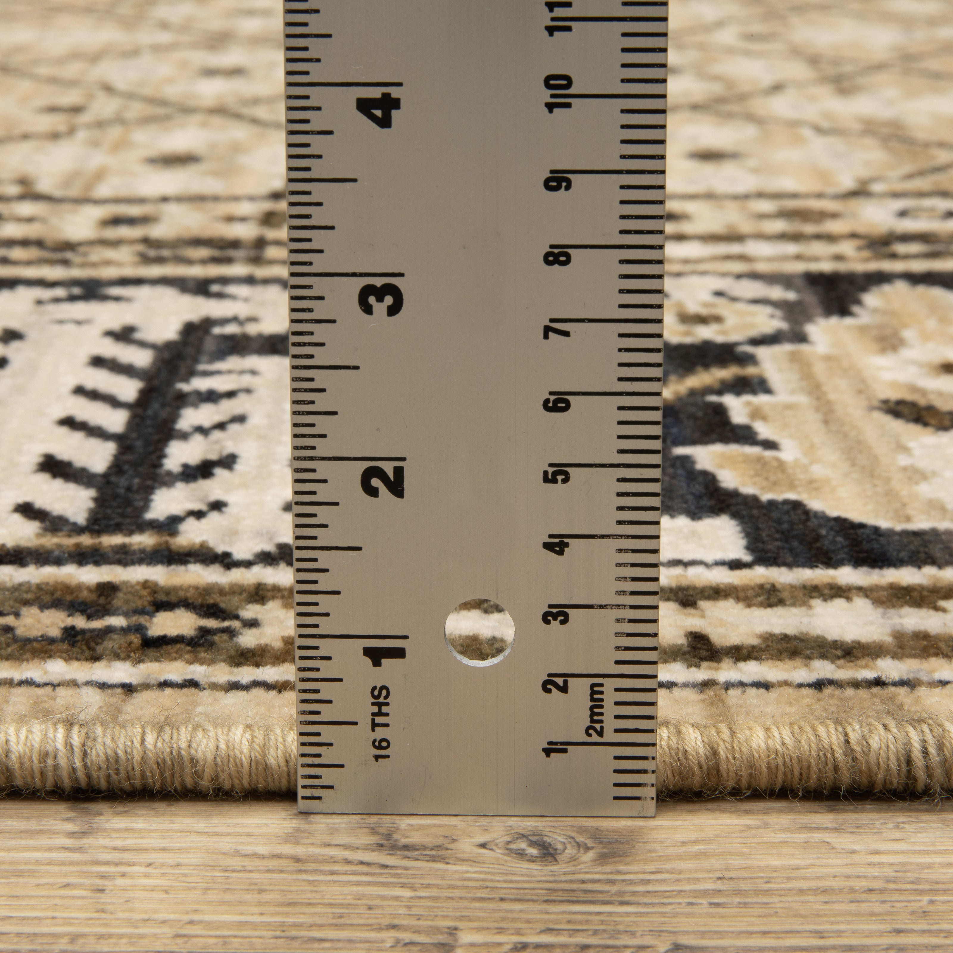 Acacia ACA12 Tan/Charcoal area rug with warm tan ground, charcoal contrast, traditional pattern detail, earthy accents, and cotton fringe.