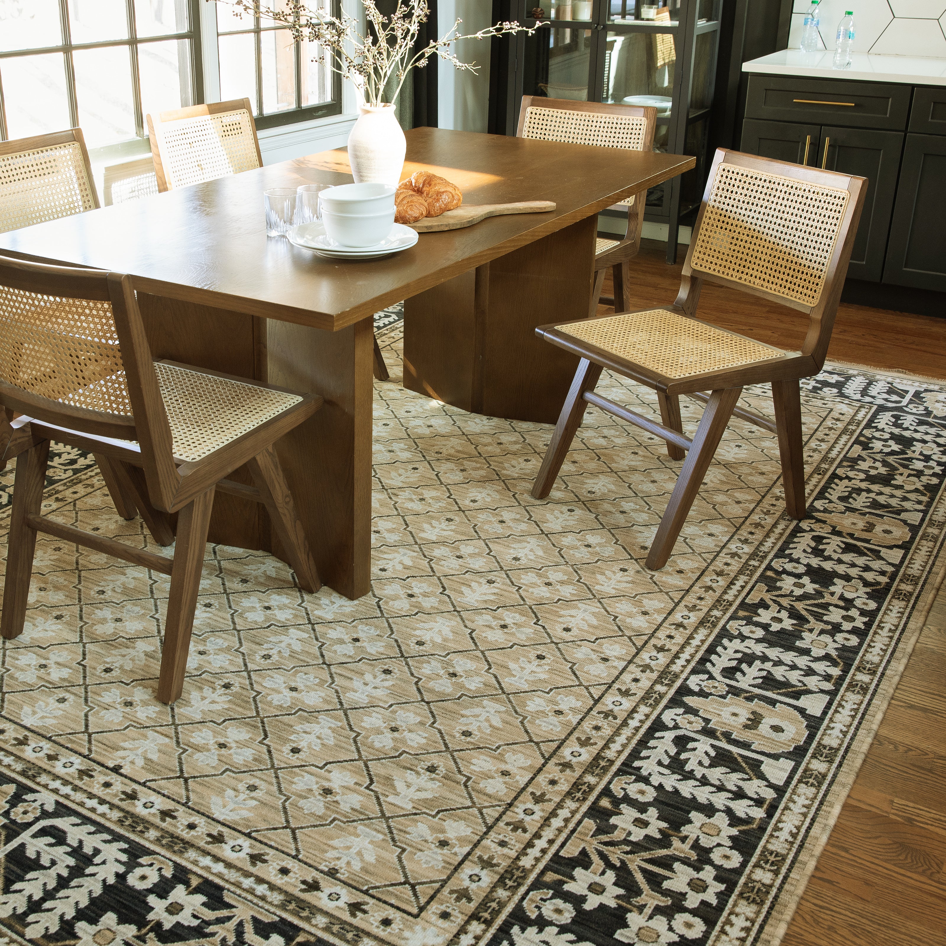 Acacia ACA12 Tan/Charcoal area rug with warm tan ground, charcoal contrast, traditional pattern detail, earthy accents, and cotton fringe.
