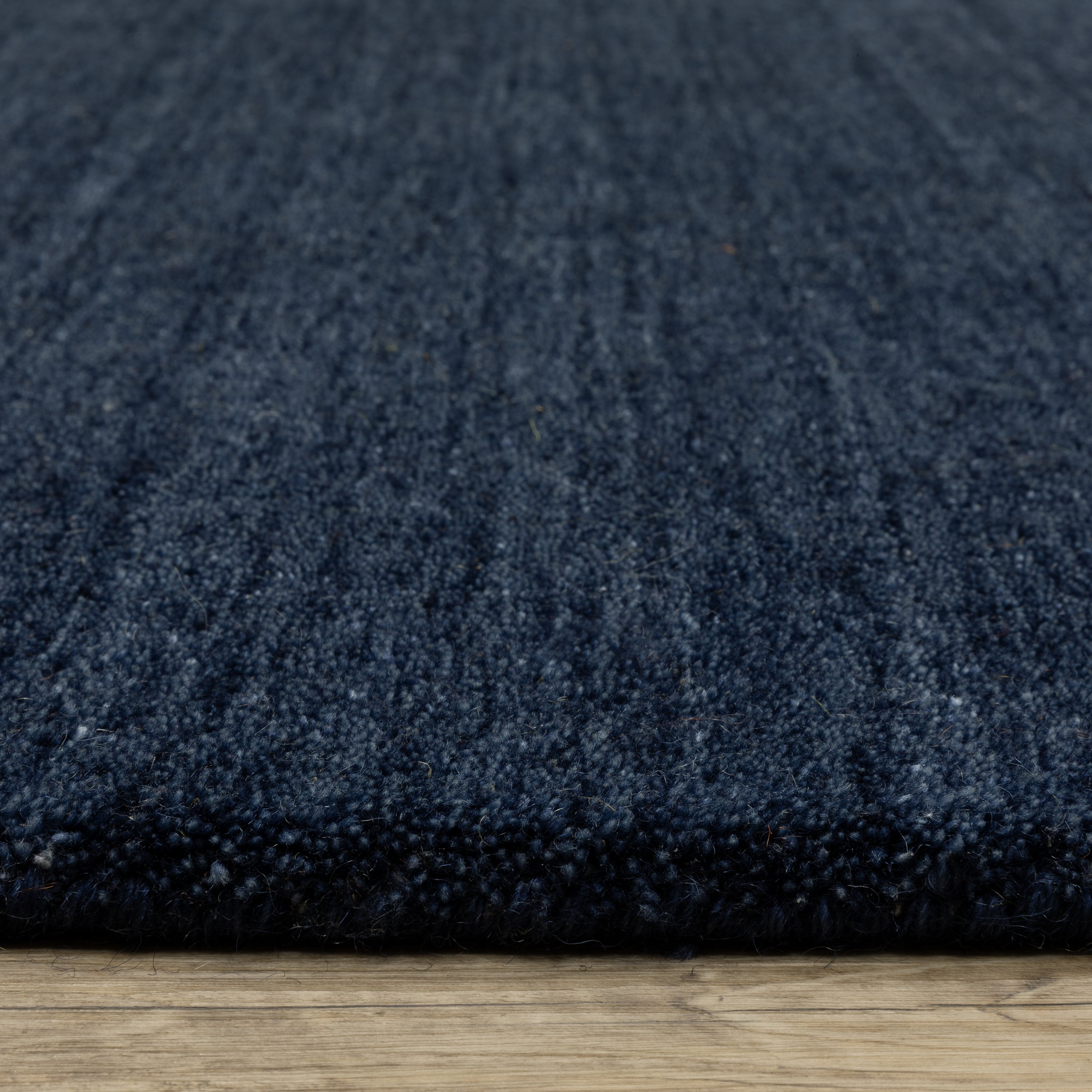 Aniston II 27119 Navy Area Rug, navy solid wool area rug with heathered texture and plush hand-tufted surface.
