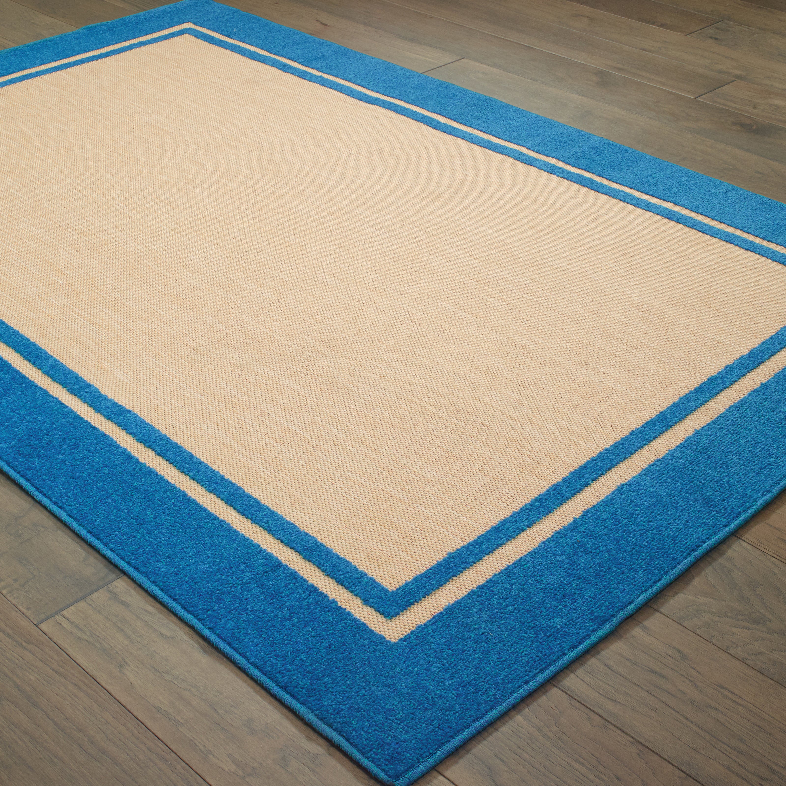 Oriental Weavers Cayman 5594B textured indoor-outdoor rug featuring abstract pattern in sand/ blue tones
