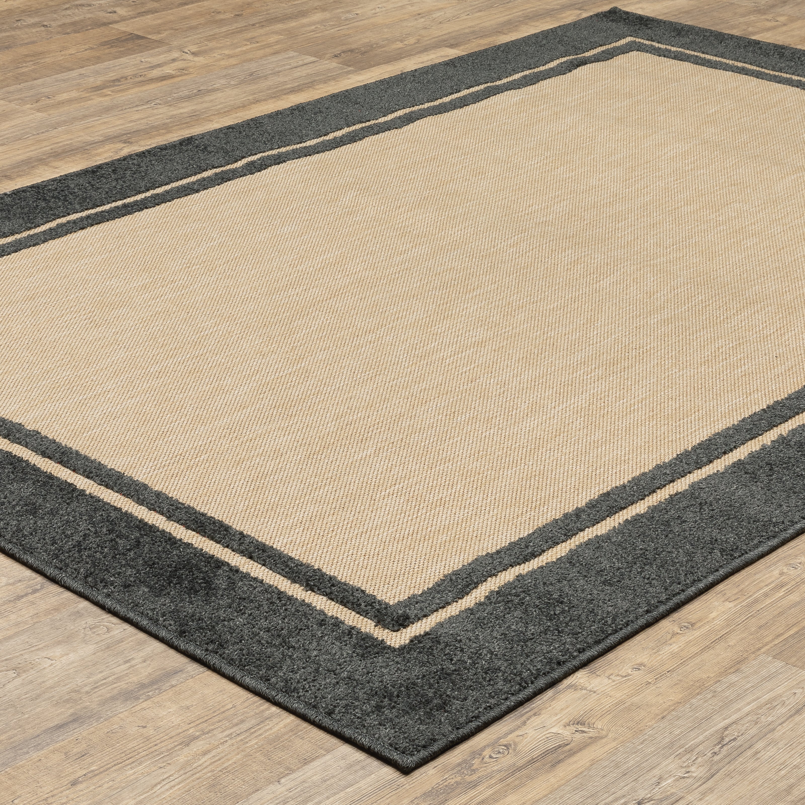 Oriental Weavers Cayman 5594K textured indoor-outdoor rug featuring abstract pattern in sand/ charcoal tones