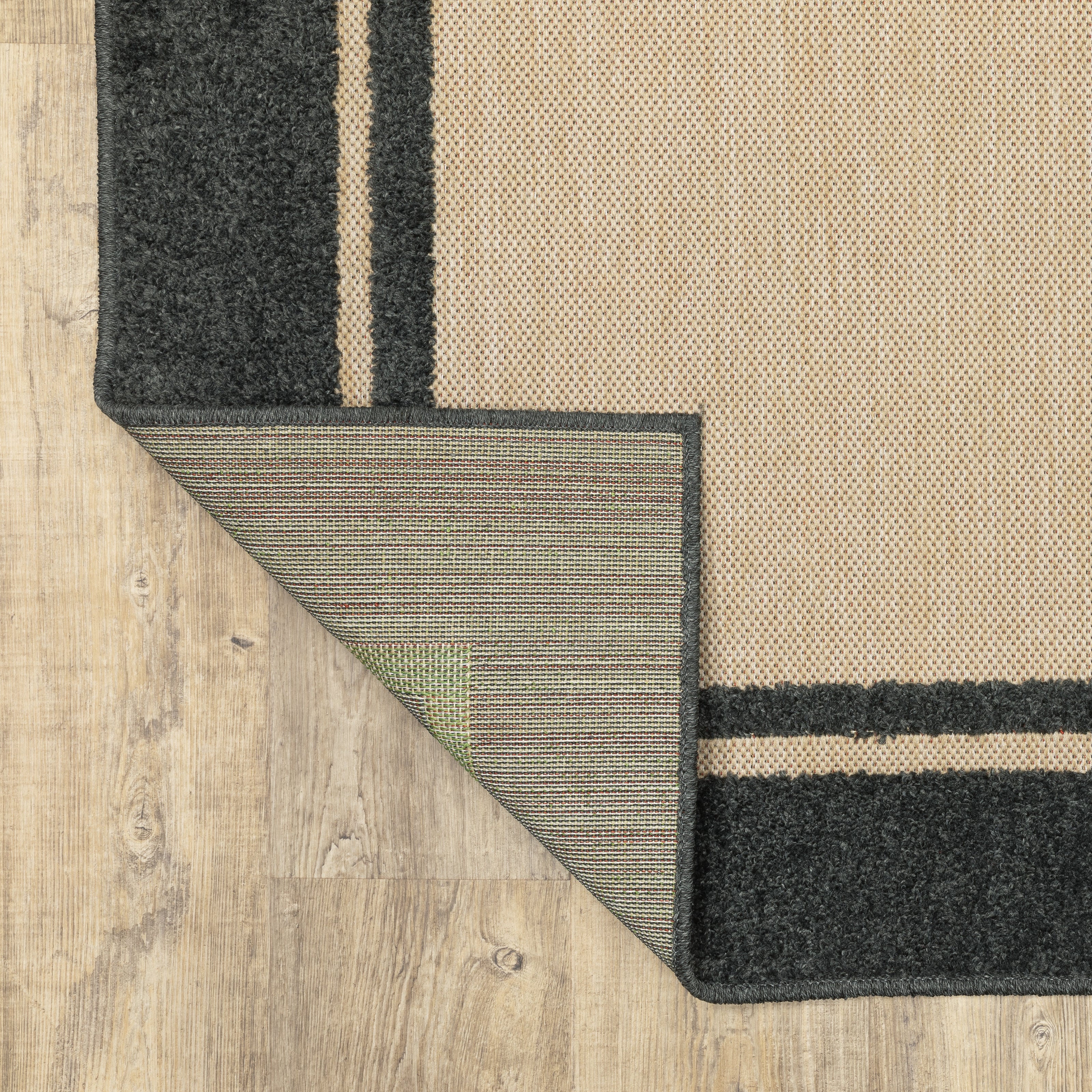 Oriental Weavers Cayman 5594K textured indoor-outdoor rug featuring abstract pattern in sand/ charcoal tones